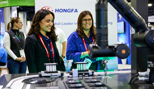 Two women smiling, standing next to equipment