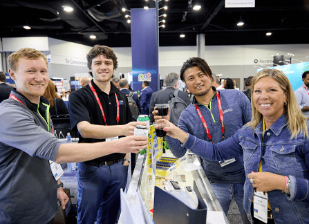 Three men and a woman holding up drinks to toast